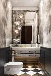 The aged tinted mirror "echoes" the motifs of the wallpaper